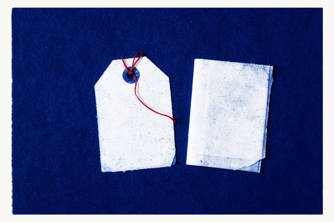 Enregistrement de marque auprès de TÜRKPATENT : une grande étiquette produit vierge reliée par son œillet, avec le fil rouge, à une chemise de documents fermée, cyanotype